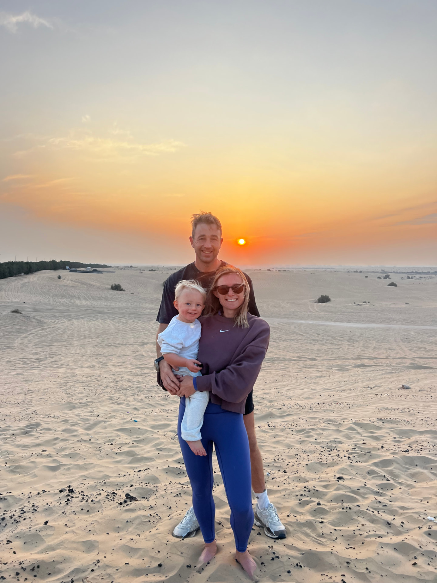 Mollie, her partner and son in the Dubai desert at sunset